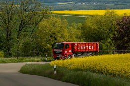 LKW fährt mit Container durch Landschaft