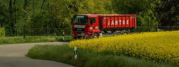 LKW fährt mit Container durch Landschaft