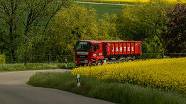 LKW fährt mit Container durch Landschaft